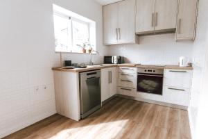 a kitchen with white cabinets and a stove top oven at Apartamento no centro da cidade in Santarém