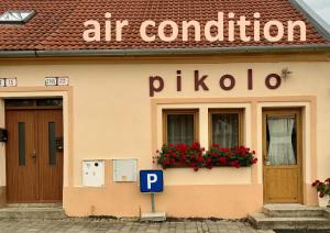 a building with a p sign in front of it at Pikolo - izby na prenájom in Nové Mesto nad Váhom