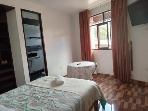 a bedroom with a bed and a table and a window at Menacho's House in Caraz