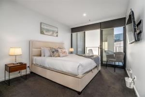 a bedroom with a bed and a table and a chair at Modern 2BR APT in Highgate Executive Apartment - Hosted by Canstay in Canberra