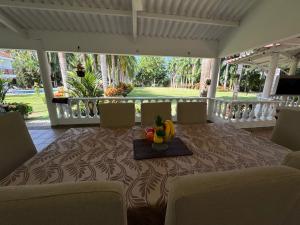 a table with a bowl of fruit on top of a porch at Finca San José, Los Naranjos Santa Marta in Santa Marta