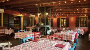 a restaurant with tables with red and white checkered tables sidx sidx sidx sidx at La Busa alloggi e trattoria in Ponte San Nicolo