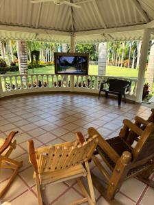 a patio with chairs and a television in a tent at Finca San José, Los Naranjos Santa Marta in Santa Marta