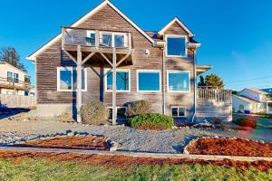 a wooden house with a porch on a street at Crystal Rose Home in Lincoln City