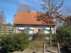 a brick house with an orange roof at Ferienhaus 702 in Tossens in Stick