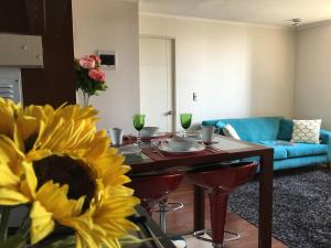 a living room with a table and a sunflower at Azzaí Bellas Artes in Santiago