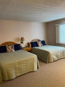 a hotel room with two beds and a window at #146 Golf, SkI, Pool Pass Walk to hill in Mancelona