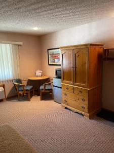 a room with a large wooden cabinet and a table at #146 Golf, SkI, Pool Pass Walk to hill in Mancelona