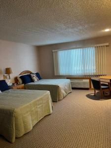 a hotel room with two beds and a window at #146 Golf, SkI, Pool Pass Walk to hill in Mancelona