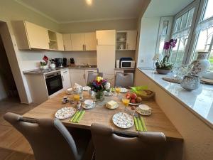 a kitchen with a wooden table with food on it at Ferienwohnung Seeschwalbe in Hagermarsch
