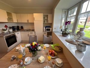 a kitchen with a table with plates and flowers on it at Ferienwohnung Seeschwalbe in Hagermarsch