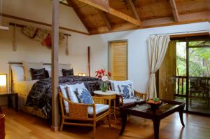 1 dormitorio con 1 cama y 1 mesa en Lotus Garden Cottages, en Volcano