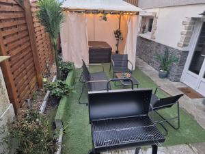 een patio met stoelen en een tafel op het gras bij Spa Privatif en Pleine Nature à 1h de Paris in Saclas