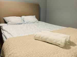 a bed with a white blanket on top of it at Cozy Blue Apartment in Vantaa