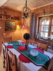 a dining room with a table with a tablecloth on it at "Koloc dom drewniany " in Ujsoły +116 photos