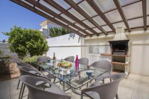 a patio with a glass table and chairs and a fireplace at Villa Maresia in Patroves