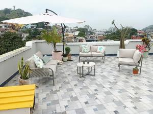 a patio with chairs and an umbrella on a roof at Freijoó Casa Vintage in Papantla de Olarte