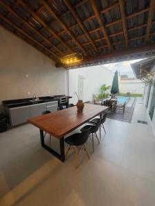 a kitchen and dining room with a wooden table and chairs at Hospedaria Casa Branca in Porto Seguro