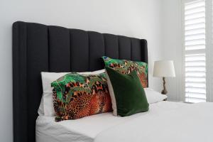 a bed with a black headboard and some pillows at Parkview for 8, Moss Vale, Southern Highlands in Moss Vale