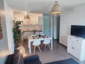 een keuken en woonkamer met een tafel en stoelen bij L'Olivier - Piscine et climatisation in Gréoux-les-Bains