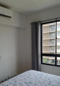 a bedroom with a bed and a window at Apto condomínio conforto e ótima localização in Lucas do Rio Verde
