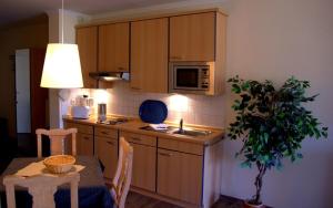 a kitchen with a table and a sink and a microwave at MeeresBlick - Urlaubstraum an der Ostsee in Kühlungsborn +13 photos