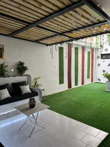 a living room with a green artificial grass at Luxueuse petite chambre, salle de bain extérieure privée in Dakar
