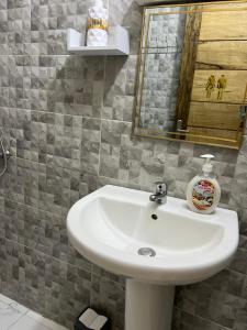 a bathroom with a white sink and a mirror at Luxueuse petite chambre, salle de bain extérieure privée in Dakar +5 photos