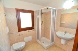 a bathroom with a shower and a toilet and a sink at Residence in Malamurì near Budoni, apartments 4 beds with private outdoor area in Budoni