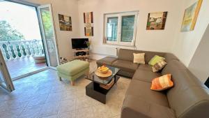 ein Wohnzimmer mit Sofa und Tisch in der Unterkunft Rose Wind Apartments by Pag tours in Pag