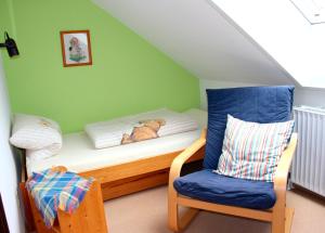 Un pequeño dormitorio con una cama y una silla. en Ferienwohnung Baumgarn, en Fehmarn