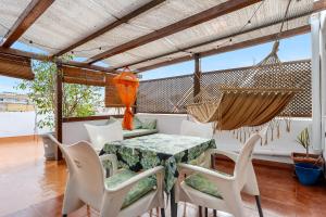 a patio with a table and chairs and a hammock at Super Terraza in Amposta