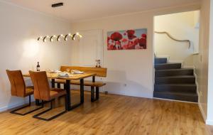 a dining room with a table and chairs and stairs at Villa Agni in Dänschendorf