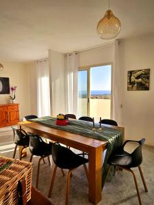 a dining room with a large wooden table and chairs at Villa Mary Holiday Home Near Villasimius in Quartu SantʼElena