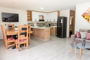 a kitchen and living room with a table and a refrigerator at La camelia in Jardin