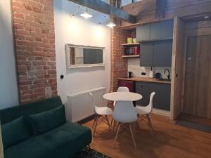 sala de estar con mesa y sofá verde en Poddasze Stare Miasto, en Olsztyn 15 fotos más