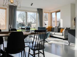 a living room with a dining table and chairs at Villa in Friesland with Jetty and Fenced Garden in Idskenhuizen