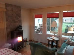 a living room with a fireplace and a stove at Haus Birkenheim in Kirchhatten