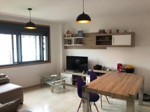 een woonkamer met een houten tafel en een televisie bij Recuncho do Susiño in Foz