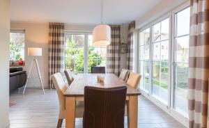 a dining room with a table and chairs and windows at Seeigel in Zingst