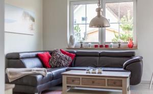 a living room with a leather couch and a coffee table at Seeigel in Zingst