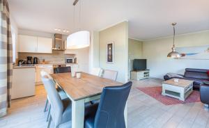a kitchen and living room with a wooden table and chairs at Seeigel in Zingst