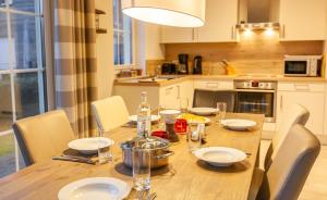a kitchen with a wooden table with chairs and a dining room at Seeigel in Zingst +13 photos