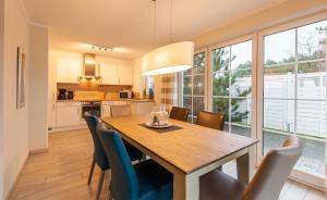 a kitchen and dining room with a wooden table and chairs at Seewolf in Zingst