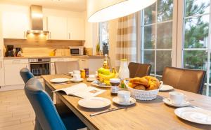 a kitchen with a wooden table with a basket of bread at Seewolf in Zingst