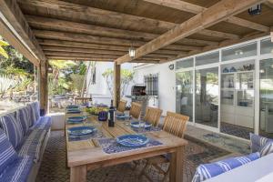 Una mesa y sillas de madera en un patio. en Casa Caribe, en São Brás de Alportel
