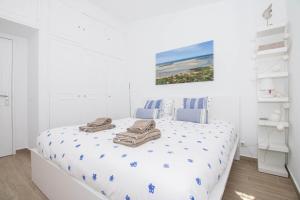 Un dormitorio blanco con una cama con toallas. en Casa Caribe, en São Brás de Alportel 53 fotos más