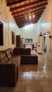 a large living room with a couch and a kitchen at Recanto da paz in Viamão