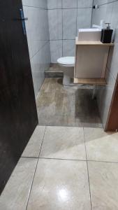 a bathroom with a toilet and a sink at Recanto da paz in Viamão