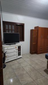 a living room with a flat screen tv on a dresser at Recanto da paz in Viamão +19 photos
